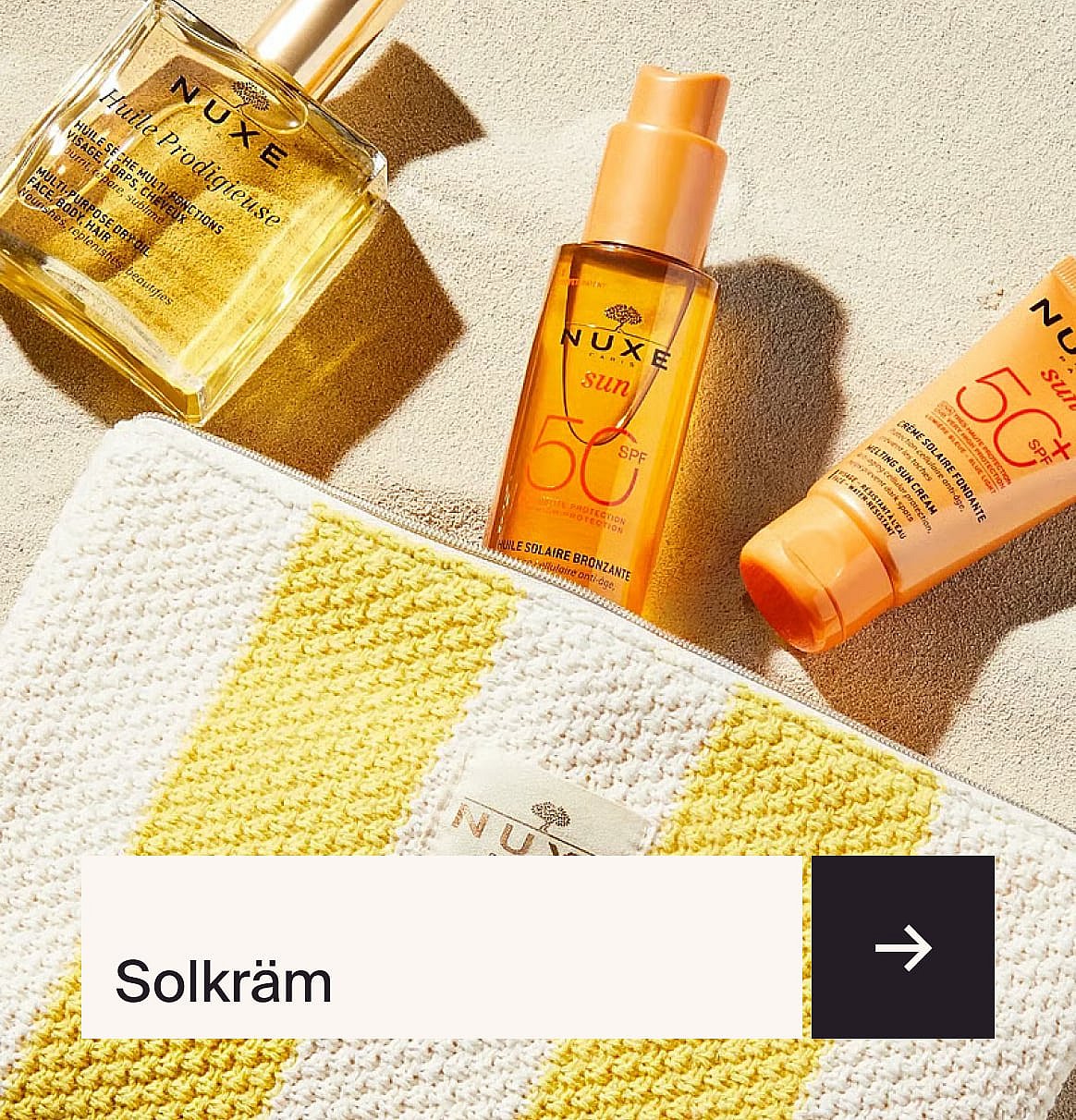 Tre solskyddsprodukter från Nuxe (torrolja, SPF 50-spray, smältande solkräm) och en gul/vitrandig necessär på sand.
