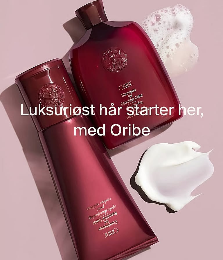 To Oribe rødrosa hårproduktflasker (sjampo, balsam) med skum og krem på en lys rosa bakgrunn. Tekstoverlegg.