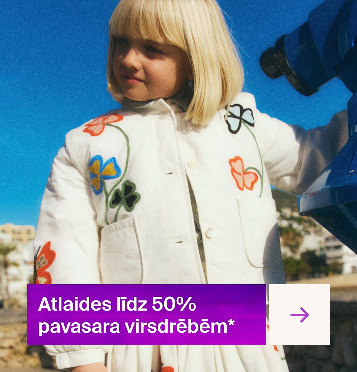 Blonds bērns izšūtā baltā jakā ārā, blakus zilam teleskopam. Violets baneris: "Pavasara atlaides līdz 50%"