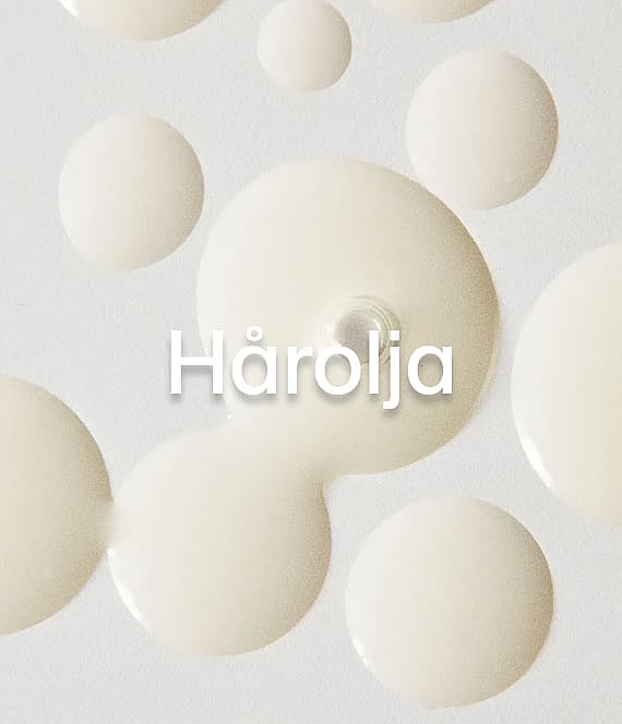 Ljusgula oljedroppar på en vit yta med texten "Hårolja".