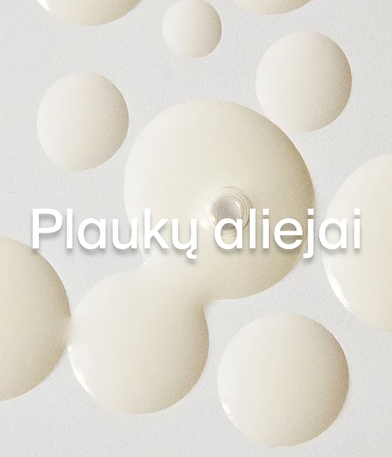 Šviesiai geltoni aliejaus lašai ant balto paviršiaus su užrašu "Hårolja".