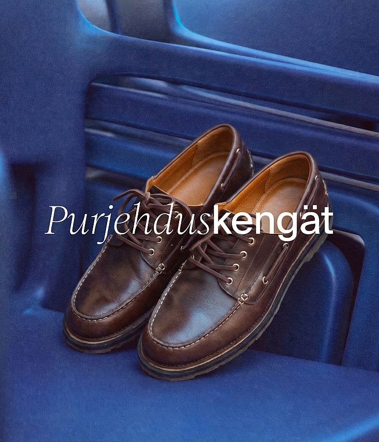 Ruskeat nahkaiset venekengät lepäävät sinisellä pinnalla. Valkoinen teksti: "Venekengät".
