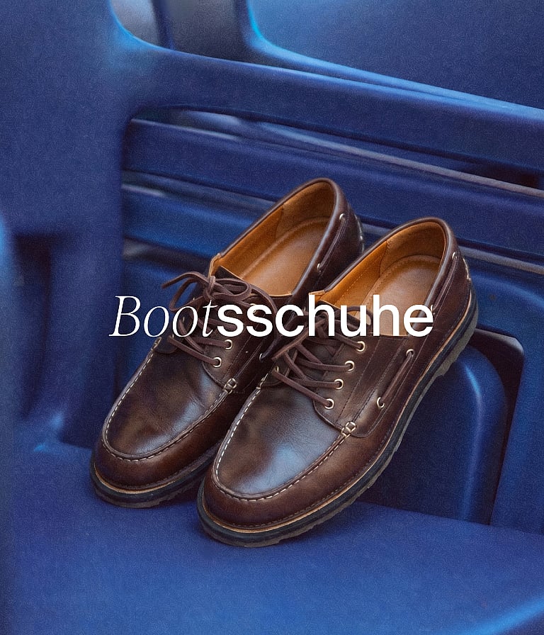Ein Paar braune Lederbootsschuhe liegt auf einer blauen Oberfläche. Weißer Text-Overlay: „Bootsschuhe“.