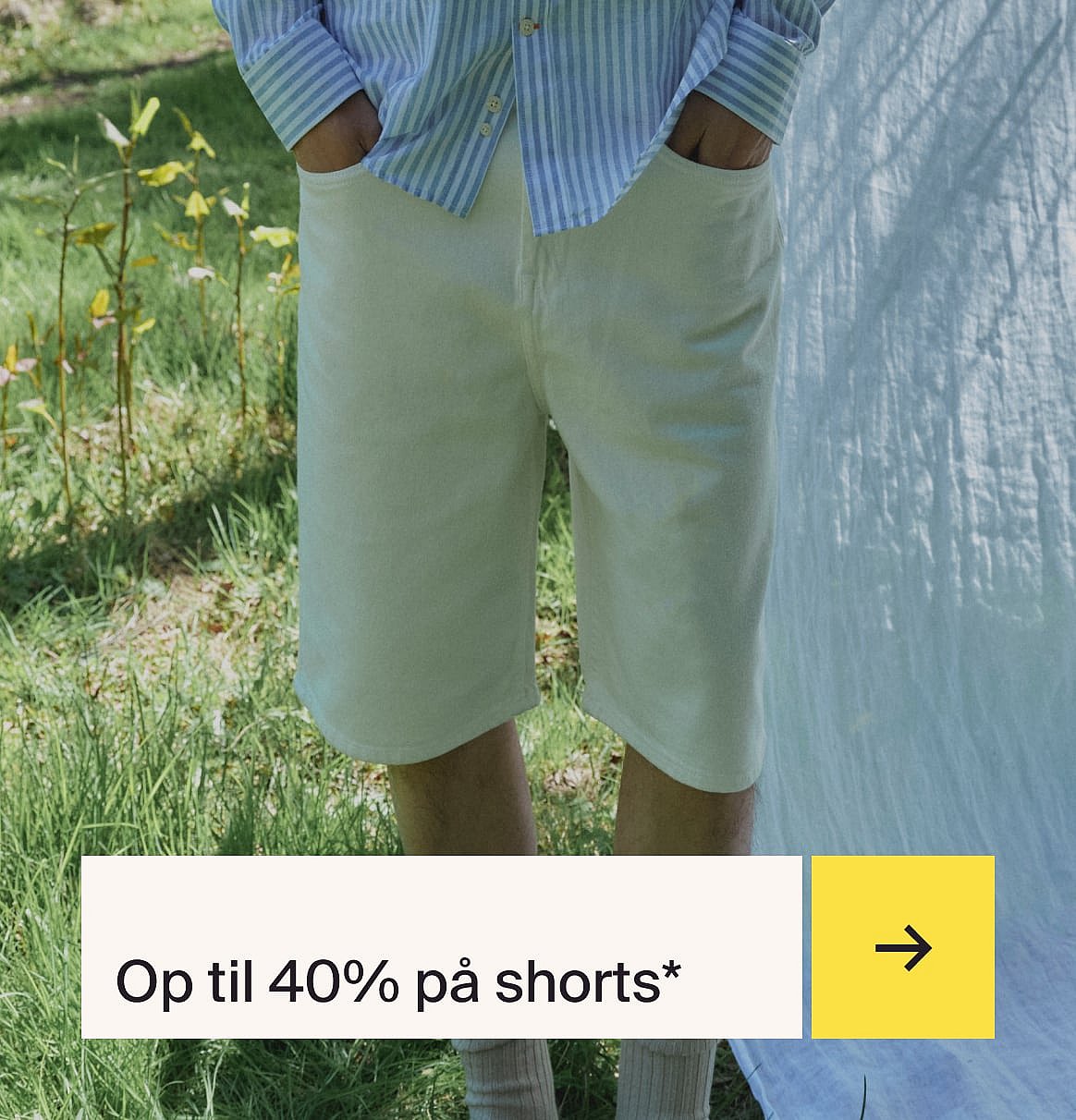 Person i stribet skjorte og lyse shorts i græsset med hvidt stof.
Op til 40% rabat på shorts.