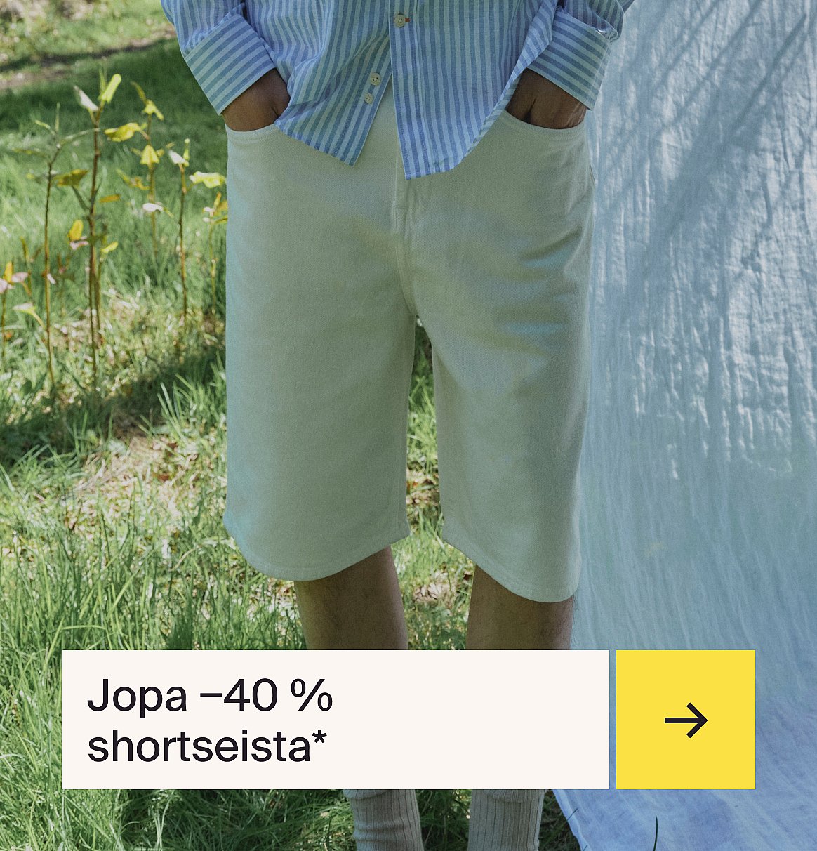 Henkilö raidallisessa paidassa ja vaaleissa shortseissa seisoo nurmikolla valkoisen kankaan kanssa.
Teksti: Shortsit jopa -40 %.