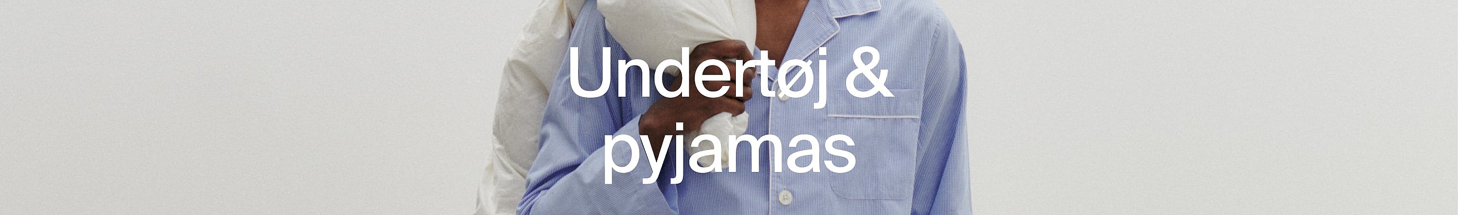 Nærbillede af to personer i pyjamas, den ene hvid, den anden blåstribet.