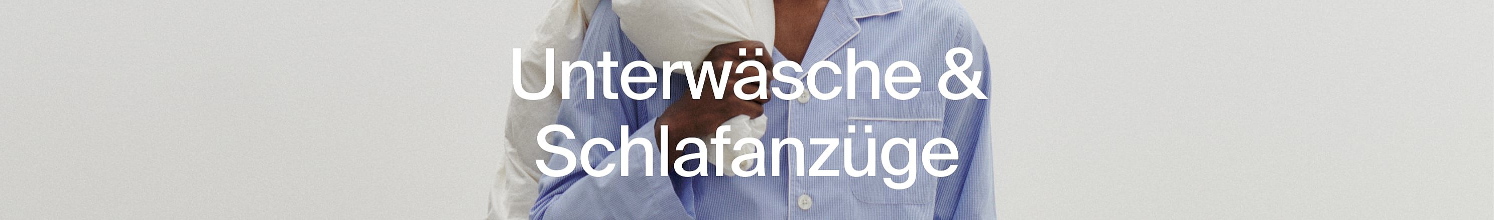 Nahaufnahme vo zwei Lüt im Pyjama, eis wiis, s'ander blau gschtreift.
