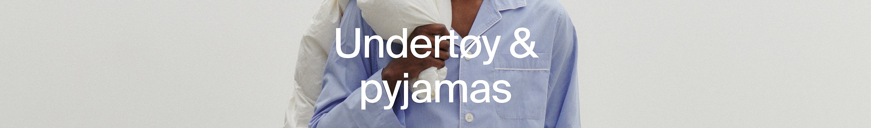 Nærbilde av to personer i pysjamas, én hvit, én blåstripet.