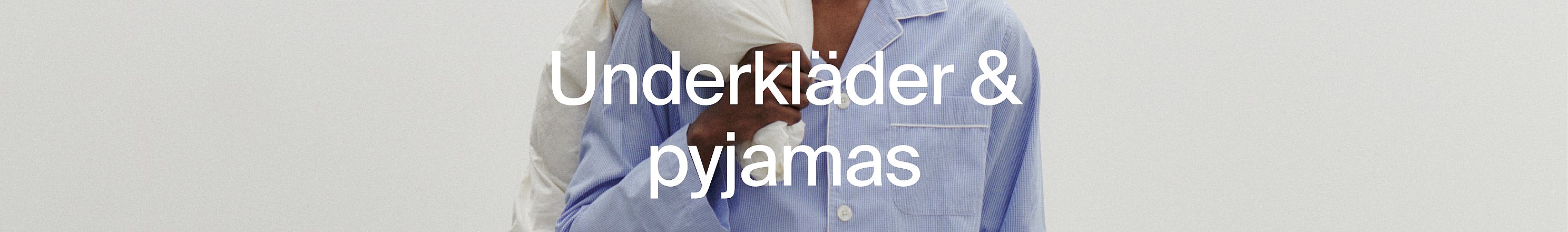 Närbild på två personer i pyjamas, en vit, en blårandig.