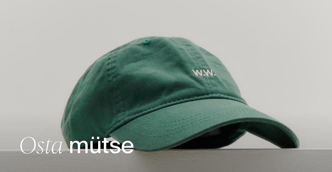 Roheline pesapallimüts valge 'W.W.' logoga, heledal taustal.
Mütsid