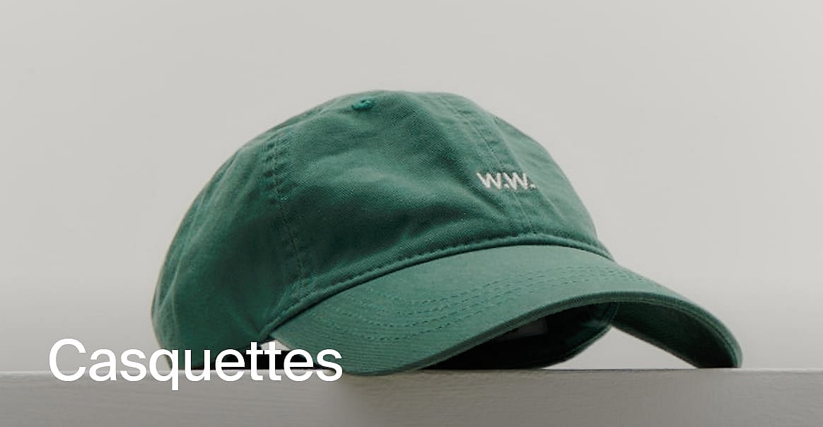 Casquette de baseball verte avec logo 'W.W.' blanc, posée sur une surface sur un fond clair. Texte : 'Acheter des casquettes'