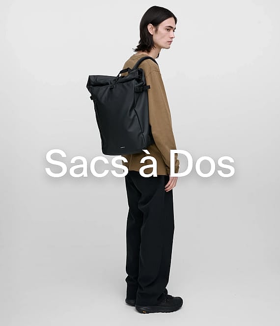 Une personne portant un sac à dos noir à enroulement et des vêtements décontractés, de profil sur fond uni.
Sacs à dos.