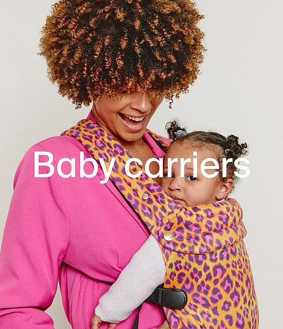 Smiling woman in pink carries baby in a leopard print carrier. Text: Baby carriers.