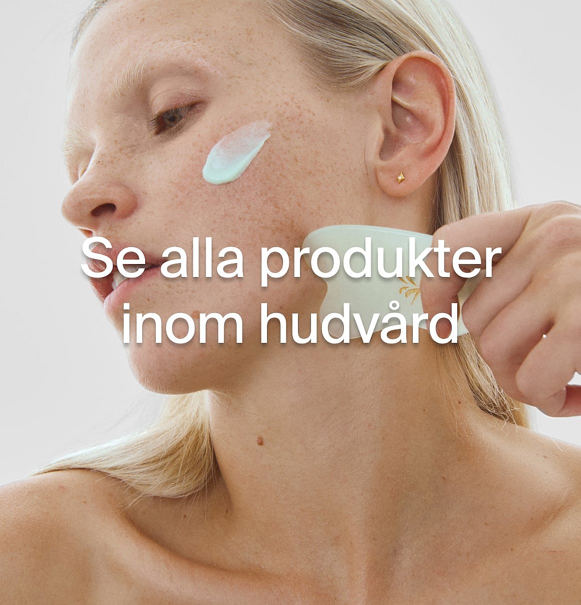 Blond person applicerar kräm på kinden och använder ett gua sha-verktyg på halsen. Text: Se alla produkter inom hudvård.