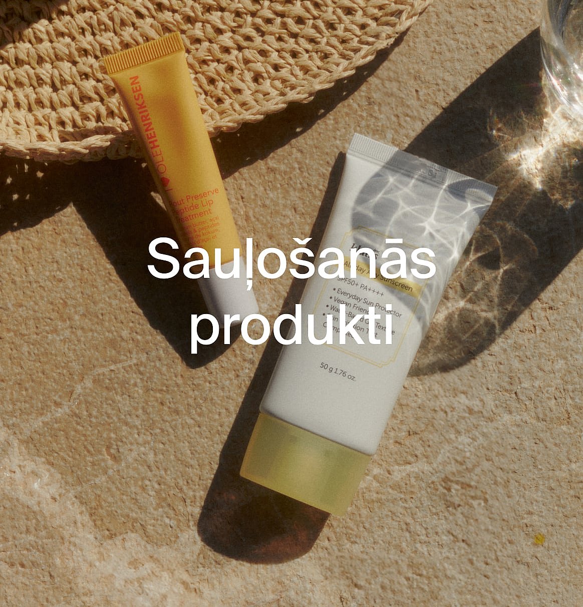 Dzeltens lūpu kopšanas līdzeklis un balta saules aizsargkrēma tūbiņa uz teksturētas virsmas ar salmu cepuri. Teksta pārklājums: Saules produkti.
