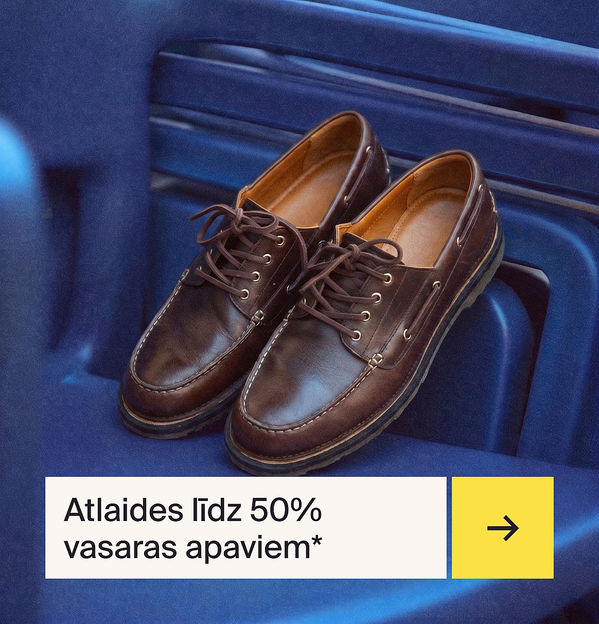 Brūnas, šņorētas ādas mokasīnu stila kurpes ar baltām vīlēm, novietotas uz zilas rievotas virsmas.