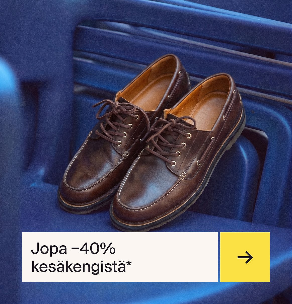 Pari ruskeita nauhallisia nahkamokasiineja valkoisilla tikkauksilla, lepäämässä sinisellä uurretulla pinnalla.