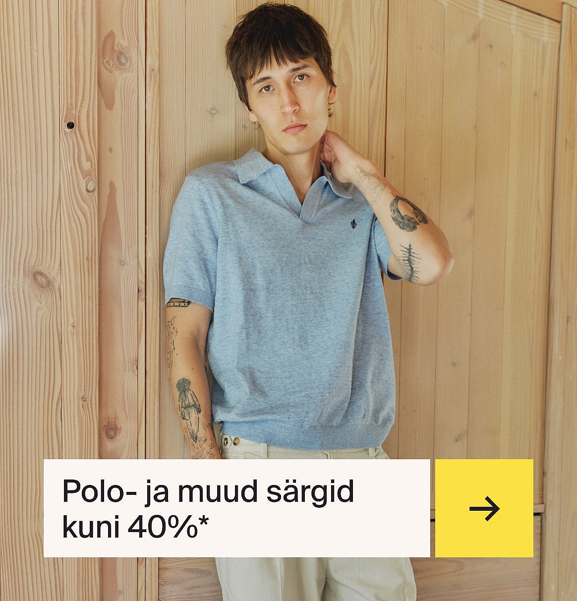 Mees helesinises särgis ja beežis linases ülikonnas istub aias väli laua taga maasikakoogiga.