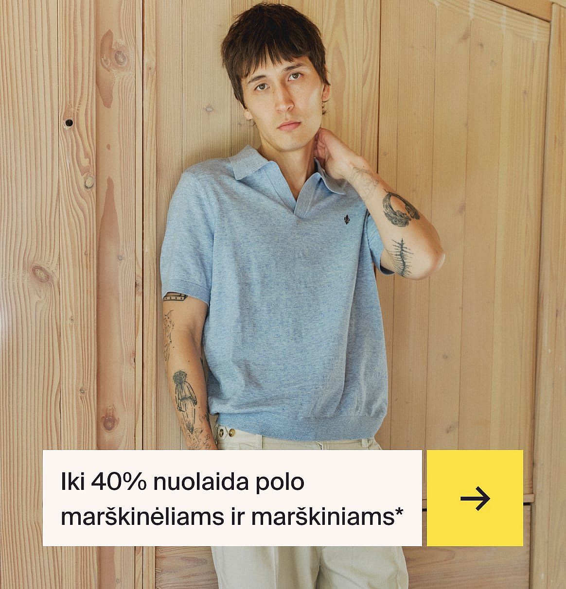 Vyras šviesiai mėlynais marškiniais ir smėlio spalvos lininiu kostiumu sėdintis prie lauko stalo su braškiniu tortu sode.