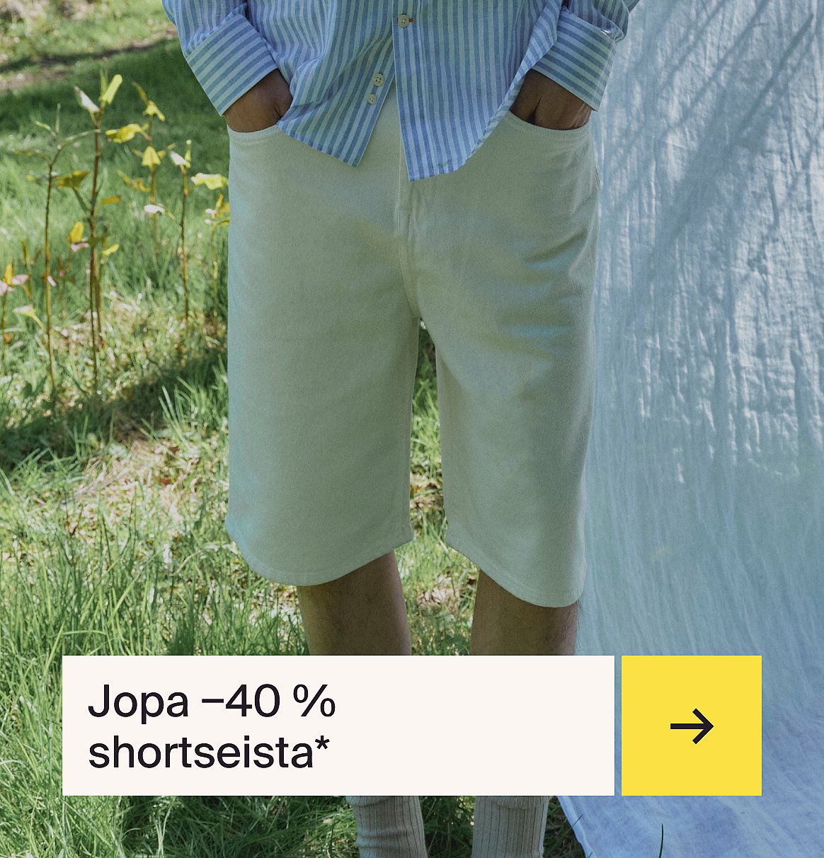 Henkilö raidallisessa paidassa ja vaaleissa shortseissa seisoo nurmikolla valkoisen kankaan kanssa.
Teksti: Shortsit jopa -40 %.