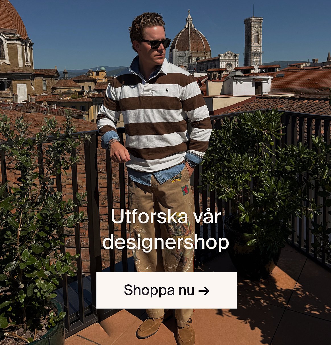 Man i en ljusbeige kostym och blå skjorta, nära ett bord med grönska, på en skogsglänta.