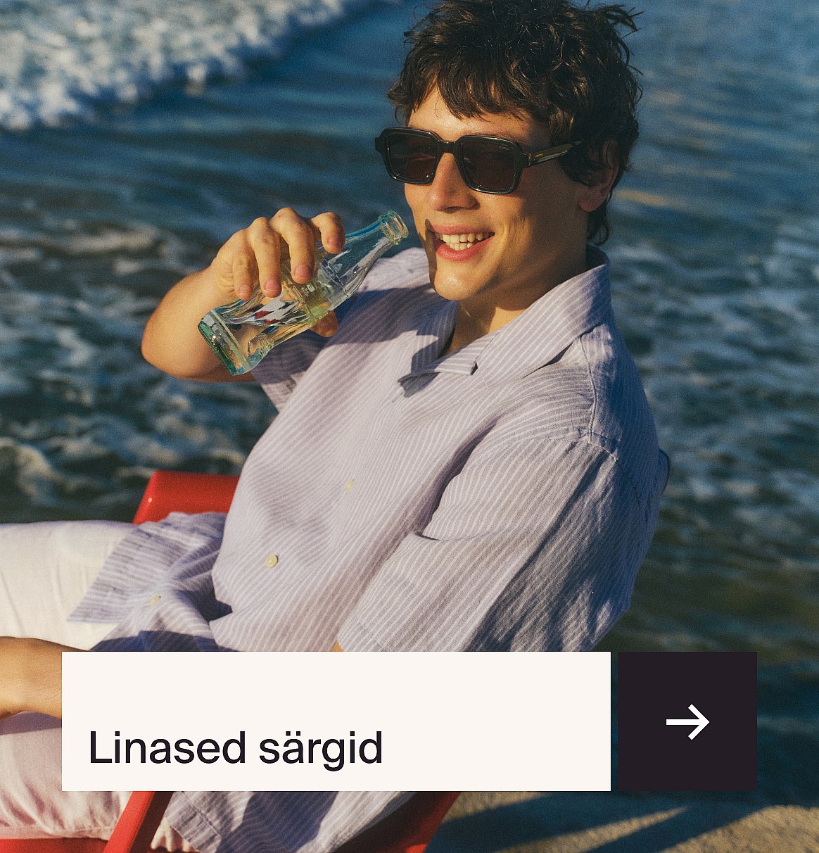 Mees helesinises särgis ja beežis linases ülikonnas istub aias väli laua taga maasikakoogiga.
