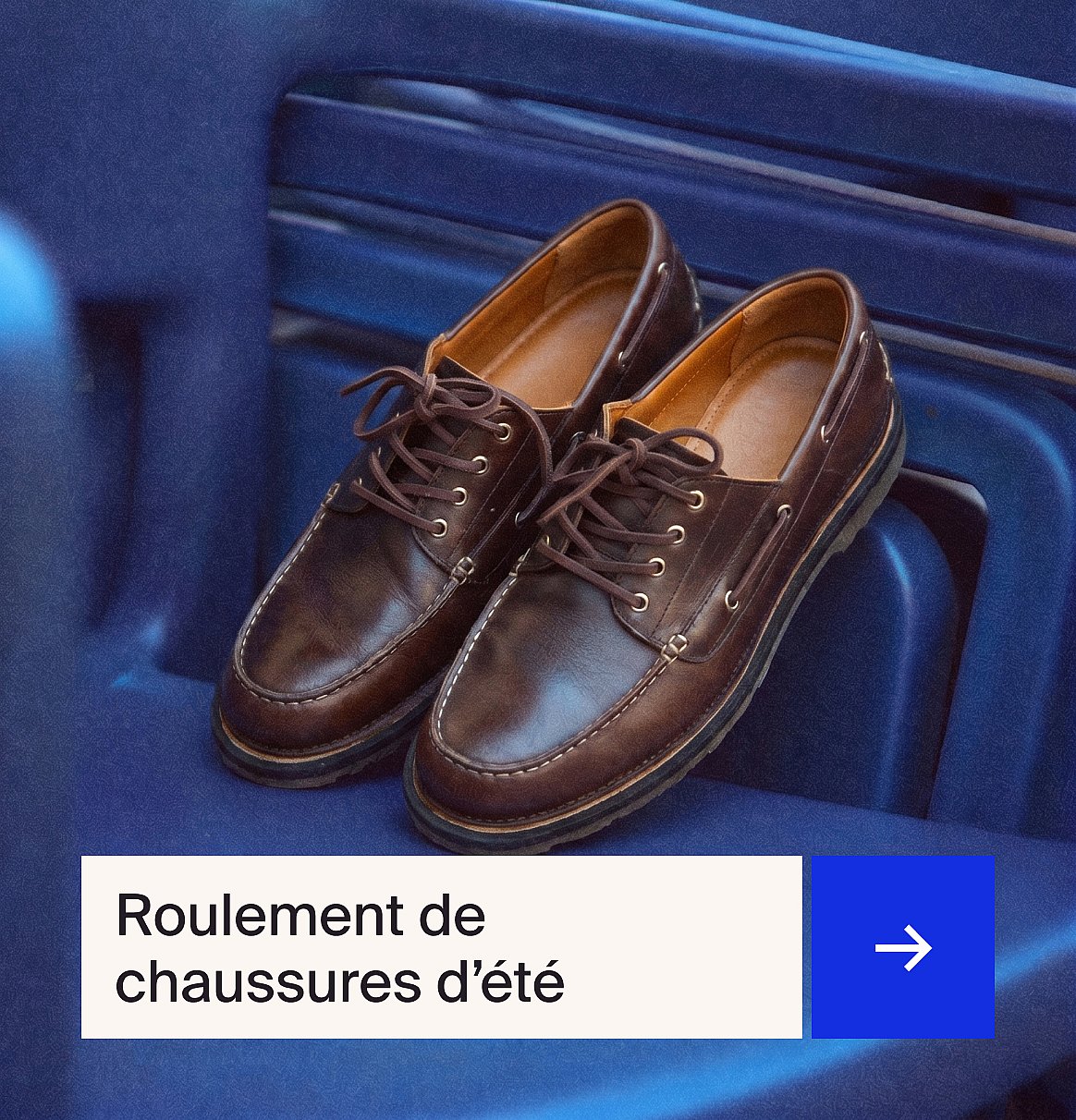 Une paire de mocassins en cuir marron à lacets avec des surpiqûres blanches, posée sur une surface bleue côtelée.