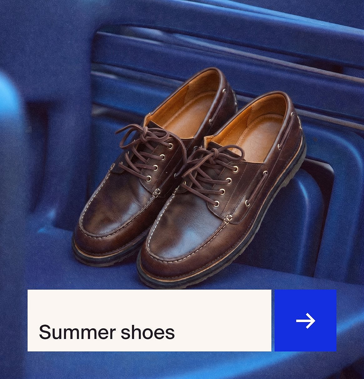 A pair of brown laced leather moccasin-style shoes with white stitching, resting on a blue ribbed surface.