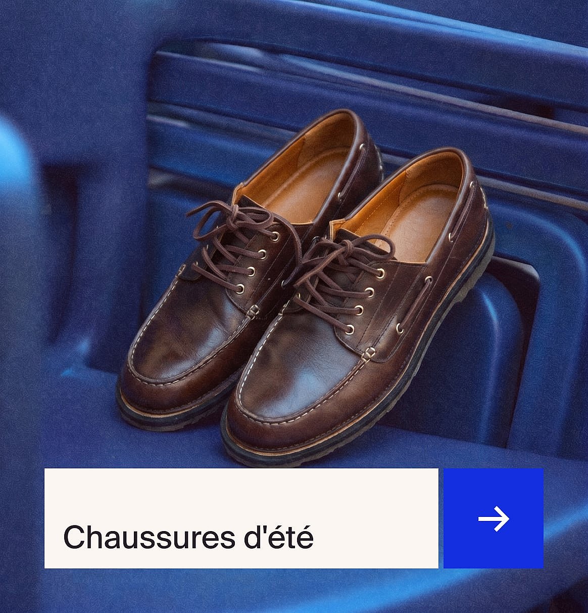 Une paire de mocassins en cuir marron à lacets avec des surpiqûres blanches, posée sur une surface bleue côtelée.