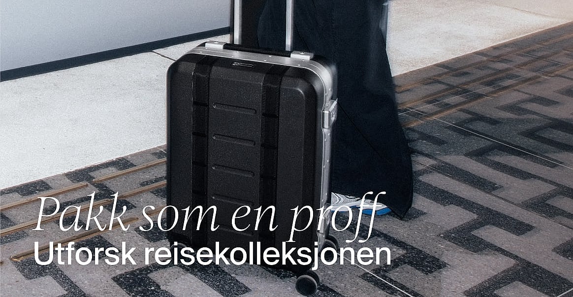 Turkise stripete badeshorts henger på en klessnor, med en solrik strand og hav i bakgrunnen. Handle badeshorts.