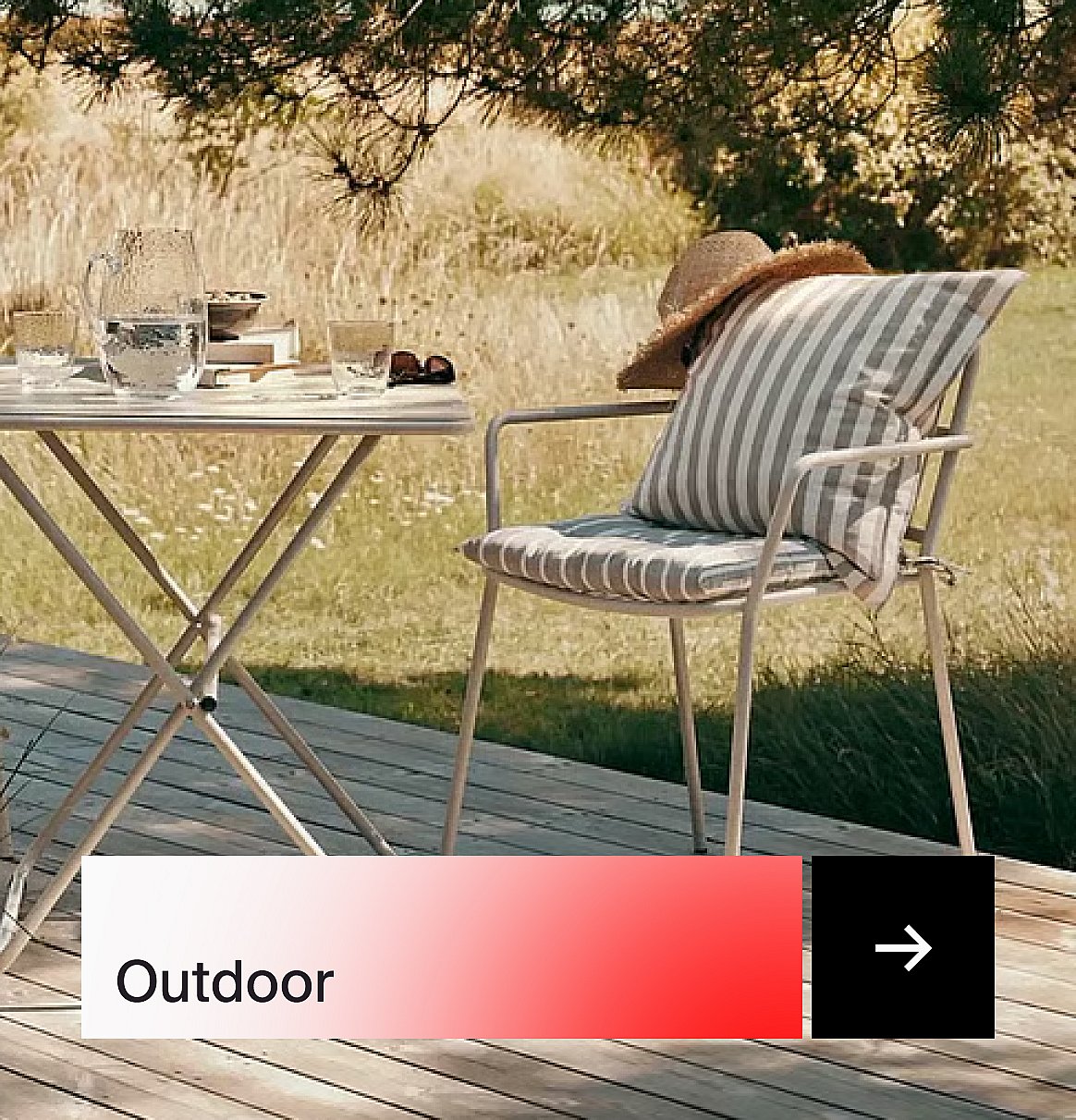 Outdoor chair with striped cushions and a straw hat, beside a table with drinks on a wooden deck.