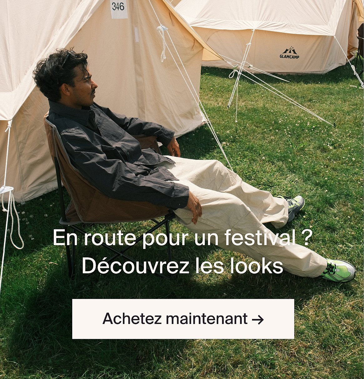Homme en costume beige clair et chemise bleue en extérieur, près d'une table avec de la verdure, dans une clairière en forêt.