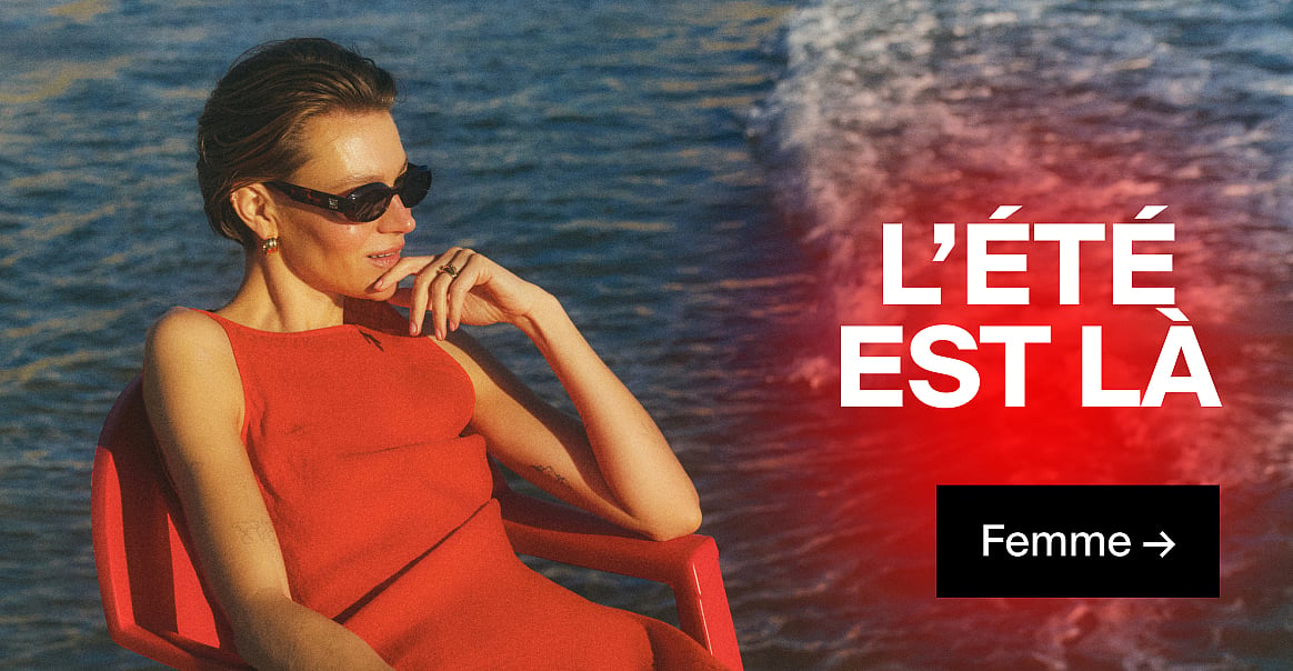 Femme en robe rouge et lunettes de soleil, la main au menton, au bord d'un plan d'eau bleu. « L'ÉTÉ EST LÀ » et « Pour elle → ».
