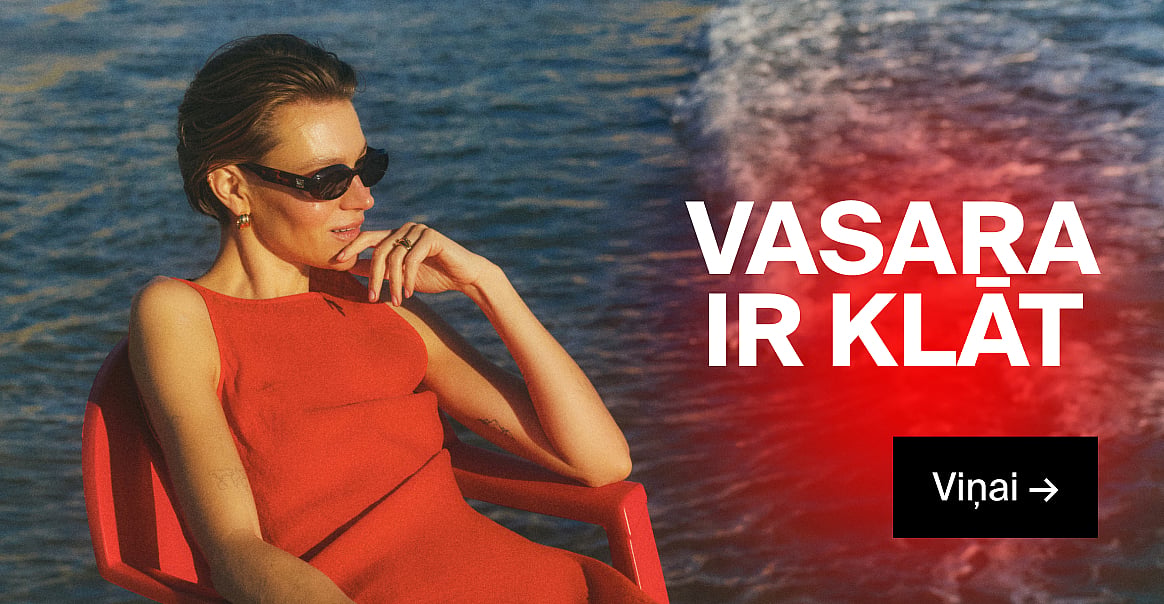 Sieviete sarkanā kleitā ar saulesbrillēm, roku pie zoda, pie zila ūdens. Uzraksti „Vasara ir klāt“ un „Viņai →“.