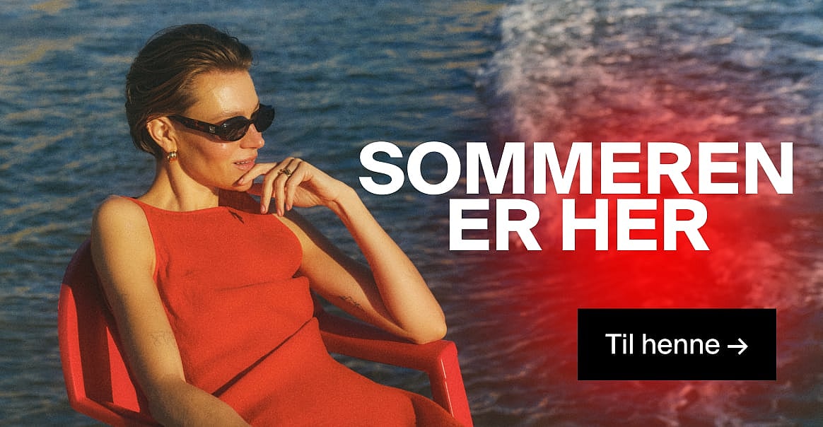 Kvinne i rød kjole og solbriller, med hånden mot haken, ved blått vann. Teksten «Sommeren er her» og «Til henne →».