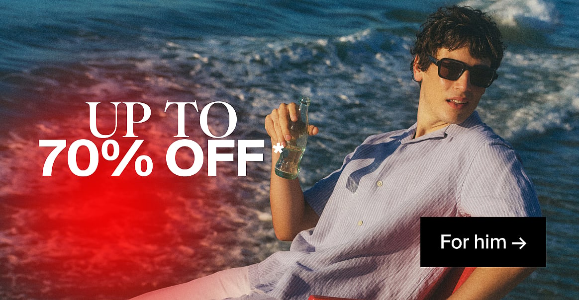 Man in sunglasses and striped shirt, holding a bottle, by the ocean. Text: UP TO 70% OFF, For him.