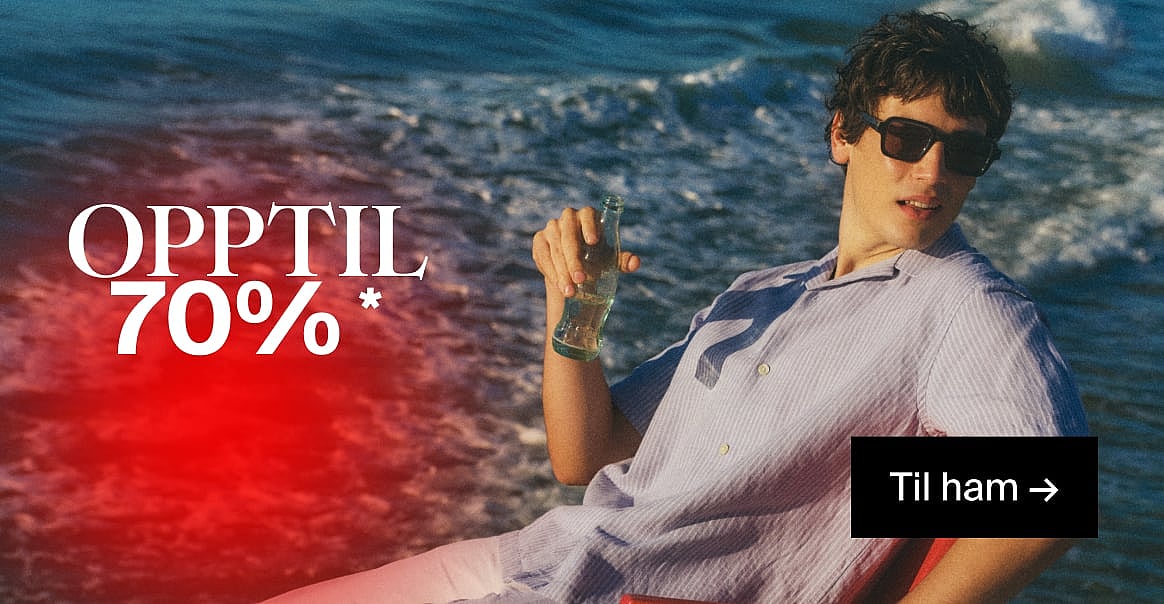 En mann med solbriller og stripete skjorte, som holder en flaske, ved havet. Tekst: OPP TIL 70% RABATT, Til ham.*