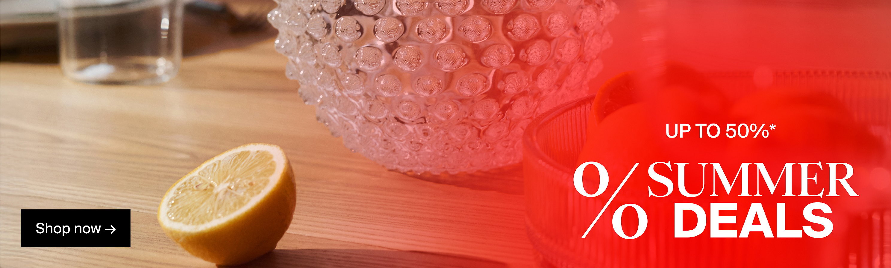 Lemon half, textured glass bowl on a wooden table with a red overlay announcing "UP TO 50%* SUMMER DEALS" and "Shop now".