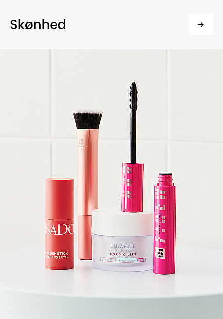 En koralrød blush-stift, en rosaguld pensel, en hvid natcreme i krukke og to lyserøde mascaraer. Tekst: Skønhed
