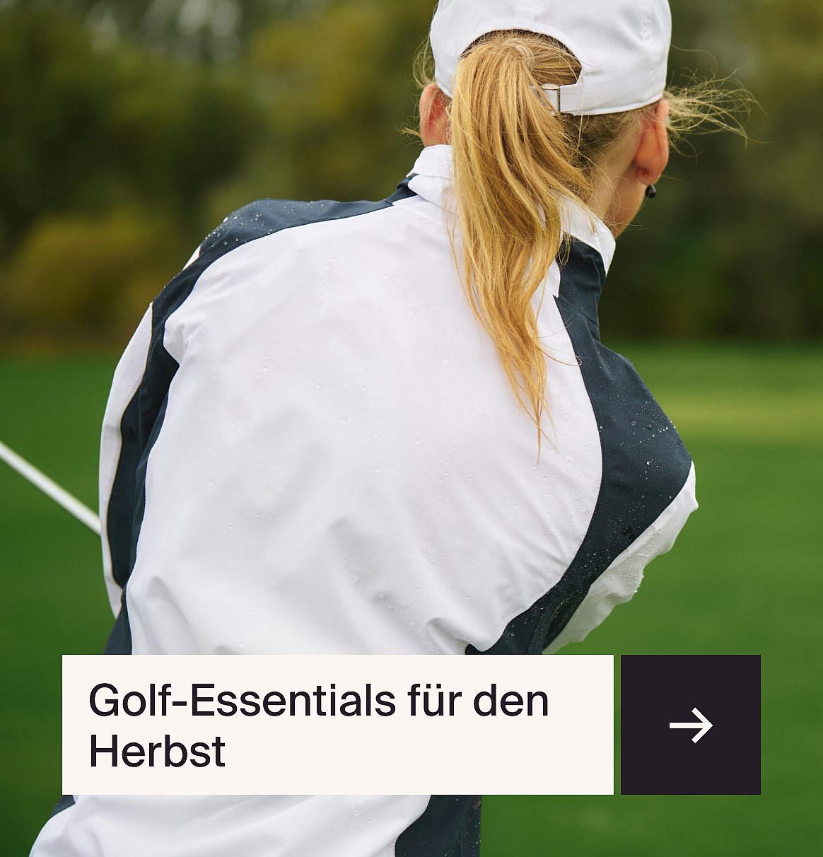 Golferin von hinten, blonde Pferdeschwanz, in einer nassen weiss-dunklen Jacke auf einem grünen Golfplatz. Text: Golf-Essentials für den Herbst.