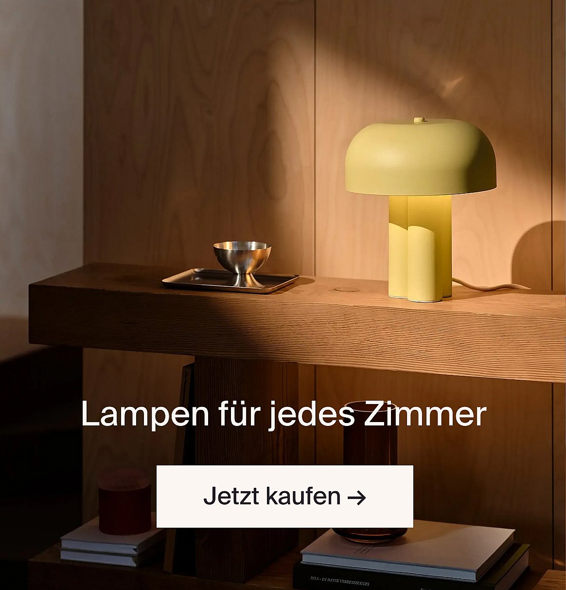 Hellgrüne Pilzlampe und silberne Schale auf einem Konsolentisch aus Holz. Text: „Lampen für jeden Raum. Jetzt einkaufen.“