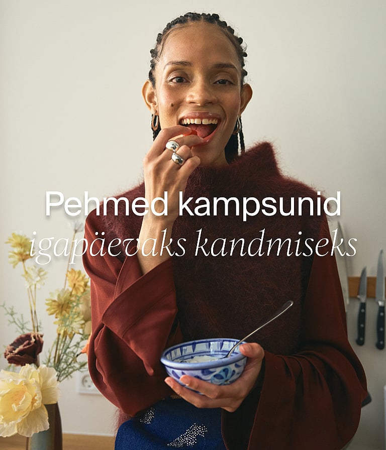 Naine heledas linases rõivastuses söömas einet mustrilise laudlinaga laua taga, akna ääres, mille taga on puud. Tekst: "Suvekontor"