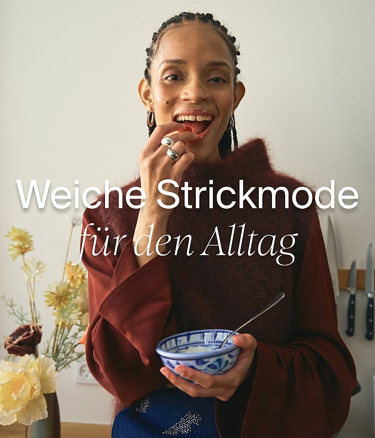 Frau in leichtem Leinen-Outfit beim Essen an einem Tisch mit gemustertem Tischtuch, am Fenster mit Bäumen. Text: "Sommerbüro"
