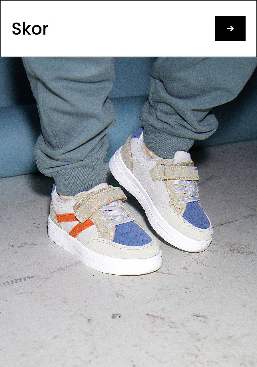Barnfötter i ljusgrå, blå och orange sneakers på ett ljusgrått golv. Text: Skor