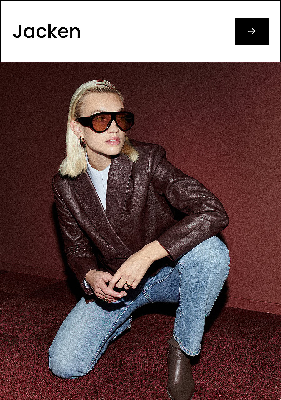 Blonde Frau mit dunkler Sonnenbrille, brauner Lederjacke, blauen Jeans und Stiefeln, die auf einem roten Teppich hockt. Text: Jacken