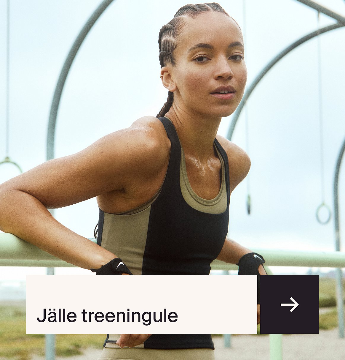 Peegeldava jope ja peegeldavate spordipäikeseprillidega naine, kes sirutab oma kätt erekollase seina taustal.