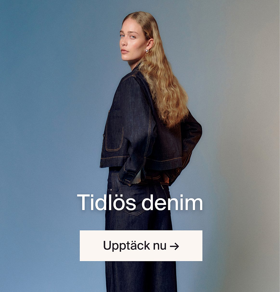 En leende kvinna i svart korsett och vit skjorta framför en trävägg. Text: Upptäck vår designbutik.