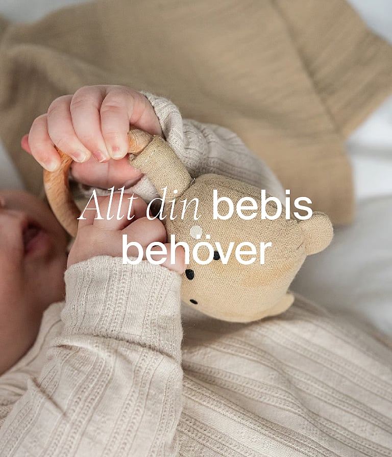 Bebisens händer i neutrala kläder som håller i en tygbjörn. Text över bilden: ”Babyprodukter”