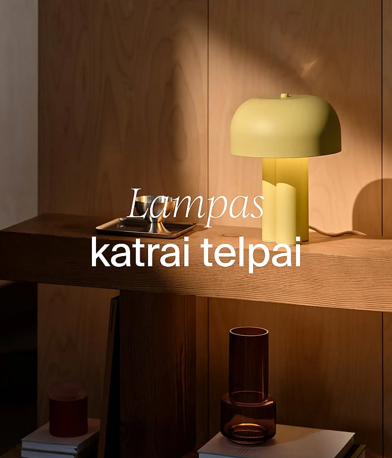 Gaiši dzeltena sēnes formas lampa uz koka konsoles galda pie koka sienas. Teksts: „Lampas katrai telpai.”