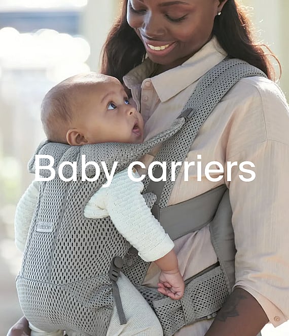 Smiling woman in pink carries baby in a leopard print carrier. Text: Baby carriers.